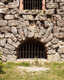 Schloss und Schlossgarten Schwetzingen - Garten - Merkurtempel - Südseite - Von außen - Von Süden - Blick auf ein Rundbogenfenster unten an der Südseite des als Ruine gebauten Merkurtempels zur Beleuchtung des Untergeschosses (Architekt: Nicolas de Pigage (1723-1796); Bauzeit: 1784-1792, Restaurierung: 2008–2013; Abmessungen: Grundfläche des Sechsecks Länge x Breite ca. 14 x 12 Meter, Länge konkave Portalseiten ca. 10 Meter, Tiefe Kabinettseiten ca. 3,5 Meter, Durchmesser Tambour ca. 6,5 Meter, Höhe ca. 25 Meter, 4 Geschosse) (aufgenommen im Juni 2025, um die Mittagszeit) Schloss und Schlossgarten Schwetzingen - Garten - Merkurtempel - Südseite - Von außen - Von Süden - Blick auf ein Rundbogenfenster unten an der Südseite des als Ruine gebauten Merkurtempels zur Beleuchtung des Untergeschosses (Architekt: Nicolas de Pigage (1723-1796); Bauzeit: 1784-1792, Restaurierung: 2008–2013; Abmessungen: Grundfläche des Sechsecks Länge x Breite ca. 14 x 12 Meter, Länge konkave Portalseiten ca. 10 Meter, Tiefe Kabinettseiten ca. 3,5 Meter, Durchmesser Tambour ca. 6,5 Meter, Höhe ca. 25 Meter, 4 Geschosse) (aufgenommen im Juni 2025, um die Mittagszeit)