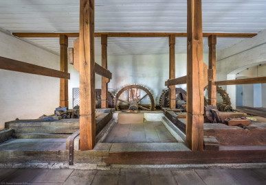 Schloss und Schlossgarten Schwetzingen - Sonstige Bauten - Oberes Wasserwerk - Pumpenstube - Von innen - Von Norden - Blick von der Nordwand des Pumpenhauses nach Süden in den Raum und auf die Pumpenanlage; hinter der Südwand befinden sich die beiden Wasserräder; in der Mitte und auf der linken Seite die Räder und Wellen der östlichen Pumpen, auf der rechten Seite die Räder und Wellen der westlichen Pumpen; die Tür ganz links führt auf einen Steg über den Leimbach und zur Schleuse vor den Wasserrädern; ganz rechts der Durchgang zwischen dem Pumpenhaus und dem Wasserturm (Gesamte Anlage Brunnenstube, Pumpenstube, Räderwerk, Wasserturm und Kühlhaus): Länge x Breite: ca. 30 x 29 Meter, Pumpenstube: Länge x Breite: ca. 13 x 9 Meter; Bauzeit Anlage: um 1774, Gesamtinstandsetzung: 1994–2000; Architekt: Nicolas de Pigage, Brunnenmeister: Thomas Breuer) (aufgenommen im Juli 2025, am Nachmittag) Schloss und Schlossgarten Schwetzingen - Sonstige Bauten - Oberes Wasserwerk - Pumpenstube - Von innen - Von Norden - Blick von der Nordwand des Pumpenhauses nach Süden in den Raum und auf die Pumpenanlage; hinter der Südwand befinden sich die beiden Wasserräder; in der Mitte und auf der linken Seite die Räder und Wellen der östlichen Pumpen, auf der rechten Seite die Räder und Wellen der westlichen Pumpen; die Tür ganz links führt auf einen Steg über den Leimbach und zur Schleuse vor den Wasserrädern; ganz rechts der Durchgang zwischen dem Pumpenhaus und dem Wasserturm (Gesamte Anlage Brunnenstube, Pumpenstube, Räderwerk, Wasserturm und Kühlhaus): Länge x Breite: ca. 30 x 29 Meter, Pumpenstube: Länge x Breite: ca. 13 x 9 Meter; Bauzeit Anlage: um 1774, Gesamtinstandsetzung: 1994–2000; Architekt: Nicolas de Pigage, Brunnenmeister: Thomas Breuer) (aufgenommen im Juli 2025, am Nachmittag)