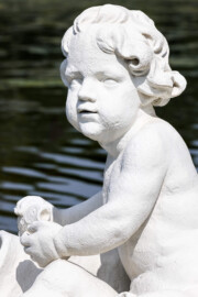 Schloss und Schlossgarten Schwetzingen - Garten - Um den Großen Weiher - Skulptur Rhein (rechts der Mitte des östlichen Ufers des Großen Weihers) - Von Südost - Blick auf den Knaben mit einem Fisch in der Hand der allegorischen Kolossalfigur "Rhein" (Bildhauer: Peter Anton von Verschaffelt (1710-1793); Datierung: 1769 - 1779; Material: gelber Sandstein, weiß gefasst; Kopie; Original im Lapidarium) (aufgenommen im Juli 2025, am späten Vormittag) Schloss und Schlossgarten Schwetzingen - Garten - Um den Großen Weiher - Skulptur Rhein (rechts der Mitte des östlichen Ufers des Großen Weihers) - Von Südost - Blick auf den Knaben mit einem Fisch in der Hand der allegorischen Kolossalfigur "Rhein" (Bildhauer: Peter Anton von Verschaffelt (1710-1793); Datierung: 1769 - 1779; Material: gelber Sandstein, weiß gefasst; Kopie; Original im Lapidarium) (aufgenommen im Juli 2025, am späten Vormittag)