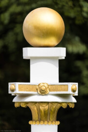 Schloss und Schlossgarten Schwetzingen - Garten - Zwischen Angloisen & Bosketten / Kugelallee - 8 Postamente mit Kugeln - Von Südost - Blick auf Details eines der acht Postamente mit vergoldeten Kugeln; Standort: im Nordwesten des Rasenfeldes; oben eine vergoldete Kugel, darunter eine Platte mit goldenen Rosetten und Kügelchen, darunter ein Kapitell aus Akanthusblättern (Bildhauer: der Werkstatt von Franz Conrad Linck (1730-1793) zugeschrieben; Datierung: um 1770; Material: Sandstein, weiß gefasst; Höhe Gesamt / Sockel: 276 / 33 Zentimeter; Inv.Nr. G 4221-4228; Kopie, Original im Depot) (aufgenommen im Juli 2025, um die Mittagszeit) Schloss und Schlossgarten Schwetzingen - Garten - Zwischen Angloisen & Bosketten / Kugelallee - 8 Postamente mit Kugeln - Von Südost - Blick auf Details eines der acht Postamente mit vergoldeten Kugeln; Standort: im Nordwesten des Rasenfeldes; oben eine vergoldete Kugel, darunter eine Platte mit goldenen Rosetten und Kügelchen, darunter ein Kapitell aus Akanthusblättern (Bildhauer: der Werkstatt von Franz Conrad Linck (1730-1793) zugeschrieben; Datierung: um 1770; Material: Sandstein, weiß gefasst; Höhe Gesamt / Sockel: 276 / 33 Zentimeter; Inv.Nr. G 4221-4228; Kopie, Original im Depot) (aufgenommen im Juli 2025, um die Mittagszeit)