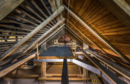 Schloss und Schlossgarten Schwetzingen - Garten - Schlosstheater - Von innen - Dachstuhl, über dem Zuschauerraum - Von Westen - Blick von der Mauer oberhalb des eisernen Vorhangs nach Osten in die oberste der drei Ebenen des historischen Dachstuhls über dem Zuschauerraum; im 18. und 20. Jahrhundert wurde der Dachstuhl mehrfach erweitert bzw. geändert (Gesamter Bau: Länge x Breite: ca. 62 x 35 Meter; Architekt: Nicolas de Pigage (1723-1796); Bauzeit: 1752-1753, Erweiterung 1762, Sanierung: 1937, Renovierung: 1952, Generalsanierung / Umbau 1971-1974, Restaurierung: 1999-2005) (aufgenommen im Juli 2025, am frühen Nachmittag) Schloss und Schlossgarten Schwetzingen - Garten - Schlosstheater - Von innen - Dachstuhl, über dem Zuschauerraum - Von Westen - Blick von der Mauer oberhalb des eisernen Vorhangs nach Osten in die oberste der drei Ebenen des historischen Dachstuhls über dem Zuschauerraum; im 18. und 20. Jahrhundert wurde der Dachstuhl mehrfach erweitert bzw. geändert (Gesamter Bau: Länge x Breite: ca. 62 x 35 Meter; Architekt: Nicolas de Pigage (1723-1796); Bauzeit: 1752-1753, Erweiterung 1762, Sanierung: 1937, Renovierung: 1952, Generalsanierung / Umbau 1971-1974, Restaurierung: 1999-2005) (aufgenommen im Juli 2025, am frühen Nachmittag)
