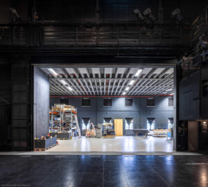 Schloss und Schlossgarten Schwetzingen - Garten - Schlosstheater - Von innen - Bühnenraum - Seitenbühne - Von Süden - Blick von der Bühne nach Norden in die (für Zuschauer nicht einsehbare) Seitenbühne; sie kann mit einem Hubtor geschlossen werden; die Seitenbühne dient als (Zwischen-) Lager für Bühnenbilder, Requisiten und Bühnentechnik, dem schnellen Kulissen- bzw. Szenenechsel sowie den Schauspielern zum Betreten und Verlassen der Bühne; links ist die Hinterbühne (nicht sichtbar), rechts der Zuschauerraum (ebenso nicht sichtbar); im Bild oben die nördliche Arbeitsgalerie mit Scheinwerfern am Geländer, im Bild rechts der nördliche Turm (mit einer Steueranlage für die Beleuchtung im schwarzen Kasten) (Gesamter Bau: Länge x Breite: ca. 62 x 35 Meter; Architekt: Nicolas de Pigage (1723-1796); Bauzeit: 1752-1753, Erweiterung 1762, Sanierung: 1937, Renovierung: 1952, Generalsanierung / Umbau 1971-1974, Restaurierung: 1999-2005) (aufgenommen im Juli 2025, am frühen Nachmittag) Schloss und Schlossgarten Schwetzingen - Garten - Schlosstheater - Von innen - Bühnenraum - Seitenbühne - Von Süden - Blick von der Bühne nach Norden in die (für Zuschauer nicht einsehbare) Seitenbühne; sie kann mit einem Hubtor geschlossen werden; die Seitenbühne dient als (Zwischen-) Lager für Bühnenbilder, Requisiten und Bühnentechnik, dem schnellen Kulissen- bzw. Szenenechsel sowie den Schauspielern zum Betreten und Verlassen der Bühne; links ist die Hinterbühne (nicht sichtbar), rechts der Zuschauerraum (ebenso nicht sichtbar); im Bild oben die nördliche Arbeitsgalerie mit Scheinwerfern am Geländer, im Bild rechts der nördliche Turm (mit einer Steueranlage für die Beleuchtung im schwarzen Kasten) (Gesamter Bau: Länge x Breite: ca. 62 x 35 Meter; Architekt: Nicolas de Pigage (1723-1796); Bauzeit: 1752-1753, Erweiterung 1762, Sanierung: 1937, Renovierung: 1952, Generalsanierung / Umbau 1971-1974, Restaurierung: 1999-2005) (aufgenommen im Juli 2025, am frühen Nachmittag)