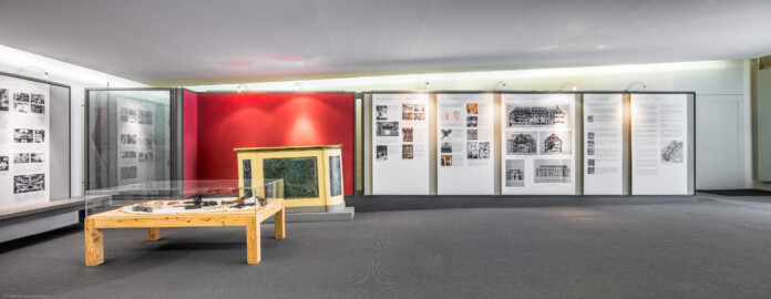 Schloss und Schlossgarten Schwetzingen - Garten - Schlosstheater - Von innen - Erdgeschoss, nördliches Foyer - Von Süden - Blick nach Norden in das nördliche Foyer im Erdgeschoss; links und rechts Tafeln einer Ausstellung zur Geschichte des Theaters; links vorne eine Vitrine mit Kulturmüllfunden, geborgen aus z.B. Hohlräumen oder Dachfußbereichen während der sanierungsbegleitenden bauhistorischen Untersuchung des Schwetzinger Hoftheaters durch Robert Erb und Peter Knoch, 1999-2005; links hinter der Vitrine ein Nachbau eines Teils der historischen Brüstung zwischen dem Parterre und dem Orchesterraum (Gesamter Bau: Länge x Breite: ca. 62 x 35 Meter; Architekt: Nicolas de Pigage (1723-1796); Bauzeit: 1752-1753, Erweiterung 1762, Sanierung: 1937, Renovierung: 1952, Generalsanierung / Umbau 1971-1974, Restaurierung: 1999-2005) (aufgenommen im August 2025, am späten Vormittag)