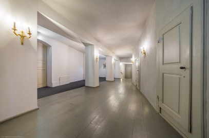 Schloss und Schlossgarten Schwetzingen - Garten - Schlosstheater - Von innen - Erdgeschoss, südliches Foyer - Von Osten - Blick vom Durchgang zum Foyer im Erdgeschoss nach Westen in das südliche Foyer; urprünglich befand sich die südliche Mauer des Theaters an der Stelle, an der heute die zwei Pfeiler stehen; beim großen Umbau 1971-1974 wurde das Schlosstheater zum nördlichen Zirkelbau (nach Süden / links) hin erweitert; originaler Bau und Anbau erkennbar am Boden: Holzboden bedeutet originaler Bau, Teppichboden bedeutet Anbau des 20. Jahrhunderts; rechts die Zugänge zu den Logen im Parterre; die große Tür links führt vom Foyer im nördlichen Zirkelbau in das südliche Foyer des Theaters; die Tür rechts der Bildmitte im Hintergrund führt zur Bühne, dem Orchestergraben und der Unterbühne (Gesamter Bau: Länge x Breite: ca. 62 x 35 Meter; Architekt: Nicolas de Pigage (1723-1796); Bauzeit: 1752-1753, Erweiterung 1762, Sanierung: 1937, Renovierung: 1952, Generalsanierung / Umbau 1971-1974, Restaurierung: 1999-2005) (aufgenommen im August 2025, am frühen Nachmittag) Schloss und Schlossgarten Schwetzingen - Garten - Schlosstheater - Von innen - Erdgeschoss, südliches Foyer - Von Osten - Blick vom Durchgang zum Foyer im Erdgeschoss nach Westen in das südliche Foyer; urprünglich befand sich die südliche Mauer des Theaters an der Stelle, an der heute die zwei Pfeiler stehen; beim großen Umbau 1971-1974 wurde das Schlosstheater zum nördlichen Zirkelbau (nach Süden / links) hin erweitert; originaler Bau und Anbau erkennbar am Boden: Holzboden bedeutet originaler Bau, Teppichboden bedeutet Anbau des 20. Jahrhunderts; rechts die Zugänge zu den Logen im Parterre; die große Tür links führt vom Foyer im nördlichen Zirkelbau in das südliche Foyer des Theaters; die Tür rechts der Bildmitte im Hintergrund führt zur Bühne, dem Orchestergraben und der Unterbühne (Gesamter Bau: Länge x Breite: ca. 62 x 35 Meter; Architekt: Nicolas de Pigage (1723-1796); Bauzeit: 1752-1753, Erweiterung 1762, Sanierung: 1937, Renovierung: 1952, Generalsanierung / Umbau 1971-1974, Restaurierung: 1999-2005) (aufgenommen im August 2025, am frühen Nachmittag)
