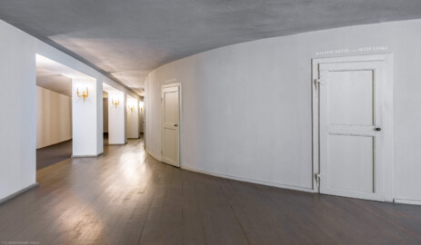 Schloss und Schlossgarten Schwetzingen - Garten - Schlosstheater - Von innen - 1. Obergeschoss (Balkon), südliches Foyer - Von Osten - Blick nach Westen in das südliche Foyer; rechts die Rückwand des hufeisenförmigen Zuschauerraums mit den Eingängen zum Balkon; urprünglich befand sich die südliche Mauer des Theaters an der Stelle, an der heute die drei Pfeiler stehen; beim großen Umbau 1971-1974 wurde das Schlosstheater zum nördlichen Zirkelbau (nach Süden / links) hin erweitert; originaler Bau und Anbau erkennbar am Boden: Holzboden bedeutet originaler Bau, Teppichboden bedeutet Anbau des 20. Jahrhunderts (Gesamter Bau: Länge x Breite: ca. 62 x 35 Meter; Architekt: Nicolas de Pigage (1723-1796); Bauzeit: 1752-1753, Erweiterung 1762, Sanierung: 1937, Renovierung: 1952, Generalsanierung / Umbau 1971-1974, Restaurierung: 1999-2005) (aufgenommen im August 2025, um die Mittagszeit)