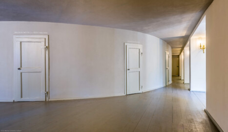 Schloss und Schlossgarten Schwetzingen - Garten - Schlosstheater - Von innen - 1. Obergeschoss (Balkon), nördliches Foyer - Von Osten - Blick von der nordöstlichen Ecke des Foyers nach Westen; in der Mitte die Rückwand des hufeisenförmigen Zuschauerraums mit den Eingängen zum Balkon; die Tür ganz rechts im Hintergrund führt in einen Technikraum (Gesamter Bau: Länge x Breite: ca. 62 x 35 Meter; Architekt: Nicolas de Pigage (1723-1796); Bauzeit: 1752-1753, Erweiterung 1762, Sanierung: 1937, Renovierung: 1952, Generalsanierung / Umbau 1971-1974, Restaurierung: 1999-2005) (aufgenommen im August 2025, am frühen Nachmittag)