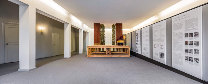 Schloss und Schlossgarten Schwetzingen - Garten - Schlosstheater - Von innen - 2. Obergeschoss (Rang), nördliches Foyer - Von Osten - Blick nach Westen in das nördliche Foyer im 2. Obergeschoss; links (südlich) hinter den Pfeilern die Zugänge zu den Rängen; mittig ein Modell einer barocken Kulissenbühne (mit verschiebbaren Kulissen); hinten mittig und rechts Tafeln zum Schlosstheater im 20. Jahrhundert, zur barocken Kulissenbühne am Drottningholmer Schlosstheater, zur barocken Bühnenmaschinerie sowie zur Bauaufnahme und Bauforschung in Schwetzingen (Gesamter Bau: Länge x Breite: ca. 62 x 35 Meter; Architekt: Nicolas de Pigage (1723-1796); Bauzeit: 1752-1753, Erweiterung 1762, Sanierung: 1937, Renovierung: 1952, Generalsanierung / Umbau 1971-1974, Restaurierung: 1999-2005) (aufgenommen im August 2025, am frühen Nachmittag) Schloss und Schlossgarten Schwetzingen - Garten - Schlosstheater - Von innen - 2. Obergeschoss (Rang), nördliches Foyer - Von Osten - Blick nach Westen in das nördliche Foyer im 2. Obergeschoss; links (südlich) hinter den Pfeilern die Zugänge zu den Rängen; mittig ein Modell einer barocken Kulissenbühne (mit verschiebbaren Kulissen); hinten mittig und rechts Tafeln zum Schlosstheater im 20. Jahrhundert, zur barocken Kulissenbühne am Drottningholmer Schlosstheater, zur barocken Bühnenmaschinerie sowie zur Bauaufnahme und Bauforschung in Schwetzingen (Gesamter Bau: Länge x Breite: ca. 62 x 35 Meter; Architekt: Nicolas de Pigage (1723-1796); Bauzeit: 1752-1753, Erweiterung 1762, Sanierung: 1937, Renovierung: 1952, Generalsanierung / Umbau 1971-1974, Restaurierung: 1999-2005) (aufgenommen im August 2025, am frühen Nachmittag)