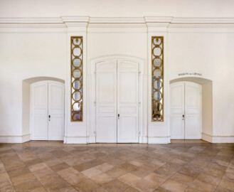 Schloss und Schlossgarten Schwetzingen - Garten - Nördlicher Zirkelbau - Westlicher Pavillon / Foyer des Schlosstheaters - Von innen - Nordwand, Mitte - Von Südwest - Blick auf die Eingangstüren zum Schlosstheater; links die Tür zum südlichen Foyer im Erdgeschoss des Schlosstheater, in der Mitte die große Eingangstür zum östlichen Foyer im Erdgeschoss des Schlosstheaters, rechts die Tür zum südöstlichen Treppenhaus für das 1. Obergeschoss (Balkon) und das 2. Obergeschoss (Rang) (Gesamter Bau: Länge Bogen ca. 175 Meter, Breite zwischen ca. 11 und 18 Meter, 51 Achsen, 5 Pavillons, 4 Zwischenbauten; Architekt: Alessandro Alessandro Galli da Bibiena (1686-1748), Bauleitung: zuerst Guillaume d’Hauberat (1680–1749), dann Nicolas de Pigage (1723-1796); Bauzeit: 1748-1750) (aufgenommen im September 2025, am späten Vormittag)