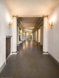 Schloss und Schlossgarten Schwetzingen - Garten - Schlosstheater - Von innen - Erdgeschoss, östliches Foyer - Von Süden - Blick von der zentralen großen Eingangstür im nördlichen Zirkelbau nach Norden in das östliche Foyer; die Tür ist geöffnet, sodass Sonnenlicht in das Foyer fallen kann; auf der linken (westlichen) Seite befindet sich vorne der Zugang zum südlichen Foyer, ganz hinten zum nördlichen Foyer, in der Mitte der zentrale Haupteingang zum Parkett des Zuschauerraums, auf der rechten (östlichen) Seite der Zugang zum ehemaligen Vestibül (Gesamter Bau: Länge x Breite: ca. 62 x 35 Meter; Architekt: Nicolas de Pigage (1723-1796); Bauzeit: 1752-1753, Erweiterung 1762, Sanierung: 1937, Renovierung: 1952, Generalsanierung / Umbau 1971-1974, Restaurierung: 1999-2005) (aufgenommen im September 2025, um die Mittagszeit)