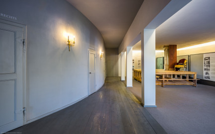 Schloss und Schlossgarten Schwetzingen - Garten - Schlosstheater - Von innen - 2. Obergeschoss (Rang), nördliches Foyer - Von Südost - Blick nach Nordwest in das nördliche Foyer im 2. Obergeschoss; urprünglich befand sich die nördliche Mauer des Theaters an der Stelle, an der heute die drei Pfeiler stehen; in den 1950/1960er Jahren und vor allem beim großen Umbau 1971-1974 wurde das Schlosstheater nach Norden hin erweitert; originaler Bau und Anbau erkennbar am Boden: Holzboden bedeutet originaler Bau, Teppichboden bedeutet Anbau des 20. Jahrhunderts; links die Zugänge zu den Rängen; rechts ein Modell einer barocken Kulissenbühne (mit verschiebbaren Kulissen) (Gesamter Bau: Länge x Breite: ca. 62 x 35 Meter; Architekt: Nicolas de Pigage (1723-1796); Bauzeit: 1752-1753, Erweiterung 1762, Sanierung: 1937, Renovierung: 1952, Generalsanierung / Umbau 1971-1974, Restaurierung: 1999-2005) (aufgenommen im September 2025, am Nachmittag) Schloss und Schlossgarten Schwetzingen - Garten - Schlosstheater - Von innen - 2. Obergeschoss (Rang), nördliches Foyer - Von Südost - Blick nach Nordwest in das nördliche Foyer im 2. Obergeschoss; urprünglich befand sich die nördliche Mauer des Theaters an der Stelle, an der heute die drei Pfeiler stehen; in den 1950/1960er Jahren und vor allem beim großen Umbau 1971-1974 wurde das Schlosstheater nach Norden hin erweitert; originaler Bau und Anbau erkennbar am Boden: Holzboden bedeutet originaler Bau, Teppichboden bedeutet Anbau des 20. Jahrhunderts; links die Zugänge zu den Rängen; rechts ein Modell einer barocken Kulissenbühne (mit verschiebbaren Kulissen) (Gesamter Bau: Länge x Breite: ca. 62 x 35 Meter; Architekt: Nicolas de Pigage (1723-1796); Bauzeit: 1752-1753, Erweiterung 1762, Sanierung: 1937, Renovierung: 1952, Generalsanierung / Umbau 1971-1974, Restaurierung: 1999-2005) (aufgenommen im September 2025, am Nachmittag)