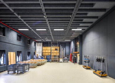 Schloss und Schlossgarten Schwetzingen - Garten - Schlosstheater - Von innen - Bühnenraum - Seitenbühne - Von Westen - Blick nach Osten in die (für die Zuschauer nicht einsehbare) Seitenbühne; die Seitenbühne dient als (Zwischen-) Lager für Bühnenbilder, Requisiten und Bühnentechnik, dem schnellen Kulissen- bzw. Szenenechsel sowie den Schauspielern zum Betreten und Verlassen der Bühne; links (nördlich) die Fenster in zwei Reihen zum Gesandtenhausgarten hin; die Stühle auf der linken Seite im Hintergrund können bei einer Schauspiel-Bestuhlung auf dem Boden des Proszeniums montiert werden; rechts (südlich) das geschlossene Seitenbühnentor, dahinter die Hauptbühne (nicht sichtbar); hinter dem Tor der Aufgang zum nördlichen Portalturm der Bühne (mit der Steueranlage für die Beleuchtung), darunter der nordöstliche Zugang zur Bühne (Gesamter Bau: Länge x Breite: ca. 62 x 35 Meter; Architekt: Nicolas de Pigage (1723-1796); Bauzeit: 1752-1753, Erweiterung 1762, Sanierung: 1937, Renovierung: 1952, Generalsanierung / Umbau 1971-1974, Restaurierung: 1999-2005) (aufgenommen im September 2025, am Nachmittag) Schloss und Schlossgarten Schwetzingen - Garten - Schlosstheater - Von innen - Bühnenraum - Seitenbühne - Von Westen - Blick nach Osten in die (für die Zuschauer nicht einsehbare) Seitenbühne; die Seitenbühne dient als (Zwischen-) Lager für Bühnenbilder, Requisiten und Bühnentechnik, dem schnellen Kulissen- bzw. Szenenechsel sowie den Schauspielern zum Betreten und Verlassen der Bühne; links (nördlich) die Fenster in zwei Reihen zum Gesandtenhausgarten hin; die Stühle auf der linken Seite im Hintergrund können bei einer Schauspiel-Bestuhlung auf dem Boden des Proszeniums montiert werden; rechts (südlich) das geschlossene Seitenbühnentor, dahinter die Hauptbühne (nicht sichtbar); hinter dem Tor der Aufgang zum nördlichen Portalturm der Bühne (mit der Steueranlage für die Beleuchtung), darunter der nordöstliche Zugang zur Bühne (Gesamter Bau: Länge x Breite: ca. 62 x 35 Meter; Architekt: Nicolas de Pigage (1723-1796); Bauzeit: 1752-1753, Erweiterung 1762, Sanierung: 1937, Renovierung: 1952, Generalsanierung / Umbau 1971-1974, Restaurierung: 1999-2005) (aufgenommen im September 2025, am Nachmittag)