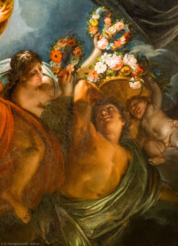 Schloss und Schlossgarten Schwetzingen - Garten - Badhaus - Von innen - Ovalsaal - Deckengemälde - Von unten - Ausschnitt aus dem Deckengemälde "Aurora vertreibt die Nacht"; rechts unterhalb der Bildmitte: Frau, Mann und Putto mit Blumenkränzen (Maler: Nicolas Guibal (1725-1784); Datierung: 1772; Signaturen: links unten "N. Guibal Lotharingus inv et fecit 1772" und rechts unten "N. Guibal Lotharingus invenit et pinxit 1772"; Öl auf Leinwand, mit vergoldeten Eichenlaubkranz eingefasst;  Restaurierungen: 1890, 1949, 2006) (Gesamter Bau: Länge x Breite ca. 18 x 14 Meter, Höhe ca. 10 Meter; Architekt: Nicolas de Pigage (1723-1796); Bauzeit: 1768-1772; Gesamtinstandsetzung innen und außen: 1999-2006) (aufgenommen im Oktober 2025, am Nachmittag)