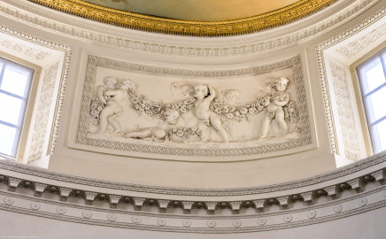 Schloss und Schlossgarten Schwetzingen - Garten - Badhaus - Von innen - Ovalsaal - Puttenfriese - Von Südwest - Nordöstliches Feld im Tambour: acht spielende Putti, verbunden durch eine Blumen- und Fruchtgirlande, ein Putto mit Blumenkorb, eingebettet in ein Feld mit Tropfenstuck, umgeben von einem glatten Rahmen (Stuckateur: Giuseppe Antonio Pozzi (1732–1811)) (Gesamter Bau: Länge x Breite ca. 18 x 14 Meter, Höhe ca. 10 Meter; Architekt: Nicolas de Pigage (1723-1796); Bauzeit: 1768-1772; Gesamtinstandsetzung innen und außen: 1999-2006) (aufgenommen im Oktober 2025, am frühen Nachmittag) Schloss und Schlossgarten Schwetzingen - Garten - Badhaus - Von innen - Ovalsaal - Puttenfriese - Von Südwest - Nordöstliches Feld im Tambour: acht spielende Putti, verbunden durch eine Blumen- und Fruchtgirlande, ein Putto mit Blumenkorb, eingebettet in ein Feld mit Tropfenstuck, umgeben von einem glatten Rahmen (Stuckateur: Giuseppe Antonio Pozzi (1732–1811)) (Gesamter Bau: Länge x Breite ca. 18 x 14 Meter, Höhe ca. 10 Meter; Architekt: Nicolas de Pigage (1723-1796); Bauzeit: 1768-1772; Gesamtinstandsetzung innen und außen: 1999-2006) (aufgenommen im Oktober 2025, am frühen Nachmittag)