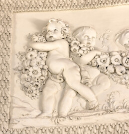 Schloss und Schlossgarten Schwetzingen - Garten - Badhaus - Von innen - Ovalsaal - Puttenfriese - Von Nordost - Ausschnitt aus dem südwestliches Feld im Tambour: spielende Putti, verbunden durch eine Blumen- und Fruchtgirlande (Stuckateur: Giuseppe Antonio Pozzi (1732–1811)) (Gesamter Bau: Länge x Breite ca. 18 x 14 Meter, Höhe ca. 10 Meter; Architekt: Nicolas de Pigage (1723-1796); Bauzeit: 1768-1772; Gesamtinstandsetzung innen und außen: 1999-2006) (aufgenommen im Oktober 2025, am frühen Nachmittag)
