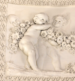 Schloss und Schlossgarten Schwetzingen - Garten - Badhaus - Von innen - Ovalsaal - Puttenfriese - Von Nordwest - Ausschnitt aus dem südöstliches Feld im Tambour: spielende Putti, verbunden durch eine Blumen- und Fruchtgirlande (Stuckateur: Giuseppe Antonio Pozzi (1732–1811)) (Gesamter Bau: Länge x Breite ca. 18 x 14 Meter, Höhe ca. 10 Meter; Architekt: Nicolas de Pigage (1723-1796); Bauzeit: 1768-1772; Gesamtinstandsetzung innen und außen: 1999-2006) (aufgenommen im Oktober 2025, am frühen Nachmittag)