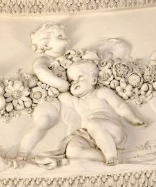 Schloss und Schlossgarten Schwetzingen - Garten - Badhaus - Von innen - Ovalsaal - Puttenfriese - Von Nordwest - Ausschnitt aus dem südöstliches Feld im Tambour: spielende Putti, verbunden durch eine Blumen- und Fruchtgirlande (Stuckateur: Giuseppe Antonio Pozzi (1732–1811)) (Gesamter Bau: Länge x Breite ca. 18 x 14 Meter, Höhe ca. 10 Meter; Architekt: Nicolas de Pigage (1723-1796); Bauzeit: 1768-1772; Gesamtinstandsetzung innen und außen: 1999-2006) (aufgenommen im Oktober 2025, am frühen Nachmittag) Schloss und Schlossgarten Schwetzingen - Garten - Badhaus - Von innen - Ovalsaal - Puttenfriese - Von Nordwest - Ausschnitt aus dem südöstliches Feld im Tambour: spielende Putti, verbunden durch eine Blumen- und Fruchtgirlande (Stuckateur: Giuseppe Antonio Pozzi (1732–1811)) (Gesamter Bau: Länge x Breite ca. 18 x 14 Meter, Höhe ca. 10 Meter; Architekt: Nicolas de Pigage (1723-1796); Bauzeit: 1768-1772; Gesamtinstandsetzung innen und außen: 1999-2006) (aufgenommen im Oktober 2025, am frühen Nachmittag)