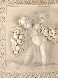 Schloss und Schlossgarten Schwetzingen - Garten - Badhaus - Von innen - Ovalsaal - Puttenfriese - Von Südost - Ausschnitt aus dem nordwestliches Feld im Tambour: spielende Putti, verbunden durch eine Blumen- und Fruchtgirlande (Stuckateur: Giuseppe Antonio Pozzi (1732–1811)) (Gesamter Bau: Länge x Breite ca. 18 x 14 Meter, Höhe ca. 10 Meter; Architekt: Nicolas de Pigage (1723-1796); Bauzeit: 1768-1772; Gesamtinstandsetzung innen und außen: 1999-2006) (aufgenommen im Oktober 2025, am frühen Nachmittag) Schloss und Schlossgarten Schwetzingen - Garten - Badhaus - Von innen - Ovalsaal - Puttenfriese - Von Südost - Ausschnitt aus dem nordwestliches Feld im Tambour: spielende Putti, verbunden durch eine Blumen- und Fruchtgirlande (Stuckateur: Giuseppe Antonio Pozzi (1732–1811)) (Gesamter Bau: Länge x Breite ca. 18 x 14 Meter, Höhe ca. 10 Meter; Architekt: Nicolas de Pigage (1723-1796); Bauzeit: 1768-1772; Gesamtinstandsetzung innen und außen: 1999-2006) (aufgenommen im Oktober 2025, am frühen Nachmittag)
