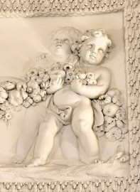 Schloss und Schlossgarten Schwetzingen - Garten - Badhaus - Von innen - Ovalsaal - Puttenfriese - Von Südwest - Ausschnitt aus dem nordöstliches Feld im Tambour: spielende Putti, verbunden durch eine Blumen- und Fruchtgirlande (Stuckateur: Giuseppe Antonio Pozzi (1732–1811)) (Gesamter Bau: Länge x Breite ca. 18 x 14 Meter, Höhe ca. 10 Meter; Architekt: Nicolas de Pigage (1723-1796); Bauzeit: 1768-1772; Gesamtinstandsetzung innen und außen: 1999-2006) (aufgenommen im Oktober 2025, am frühen Nachmittag) Schloss und Schlossgarten Schwetzingen - Garten - Badhaus - Von innen - Ovalsaal - Puttenfriese - Von Südwest - Ausschnitt aus dem nordöstliches Feld im Tambour: spielende Putti, verbunden durch eine Blumen- und Fruchtgirlande (Stuckateur: Giuseppe Antonio Pozzi (1732–1811)) (Gesamter Bau: Länge x Breite ca. 18 x 14 Meter, Höhe ca. 10 Meter; Architekt: Nicolas de Pigage (1723-1796); Bauzeit: 1768-1772; Gesamtinstandsetzung innen und außen: 1999-2006) (aufgenommen im Oktober 2025, am frühen Nachmittag)