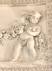 Schloss und Schlossgarten Schwetzingen - Garten - Badhaus - Von innen - Ovalsaal - Puttenfriese - Von Südwest - Ausschnitt aus dem nordöstliches Feld im Tambour: spielende Putti, verbunden durch eine Blumen- und Fruchtgirlande (Stuckateur: Giuseppe Antonio Pozzi (1732–1811)) (Gesamter Bau: Länge x Breite ca. 18 x 14 Meter, Höhe ca. 10 Meter; Architekt: Nicolas de Pigage (1723-1796); Bauzeit: 1768-1772; Gesamtinstandsetzung innen und außen: 1999-2006) (aufgenommen im Oktober 2025, am frühen Nachmittag)