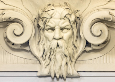 Schloss und Schlossgarten Schwetzingen - Garten - Badhaus - Von innen - Ovalsaal - Nördliche Eingangstür - Von Süden - Blick von der Mitte des Ovalsaals nach Norden auf den Neptunskopf in der Rundbogennische der nördlichen Tür; Neptunskopf bärtig, mit Schilf im Haar; beiderseits des Kopfes Voluten (Stuckateur: Giuseppe Antonio Pozzi (1732–1811) zugeschrieben) (Gesamter Bau: Länge x Breite ca. 18 x 14 Meter, Höhe ca. 10 Meter; Architekt: Nicolas de Pigage (1723-1796); Bauzeit: 1768-1772; Gesamtinstandsetzung innen und außen: 1999-2006) (aufgenommen im Oktober 2025, am Nachmittag) Schloss und Schlossgarten Schwetzingen - Garten - Badhaus - Von innen - Ovalsaal - Nördliche Eingangstür - Von Süden - Blick von der Mitte des Ovalsaals nach Norden auf den Neptunskopf in der Rundbogennische der nördlichen Tür; Neptunskopf bärtig, mit Schilf im Haar; beiderseits des Kopfes Voluten (Stuckateur: Giuseppe Antonio Pozzi (1732–1811) zugeschrieben) (Gesamter Bau: Länge x Breite ca. 18 x 14 Meter, Höhe ca. 10 Meter; Architekt: Nicolas de Pigage (1723-1796); Bauzeit: 1768-1772; Gesamtinstandsetzung innen und außen: 1999-2006) (aufgenommen im Oktober 2025, am Nachmittag)