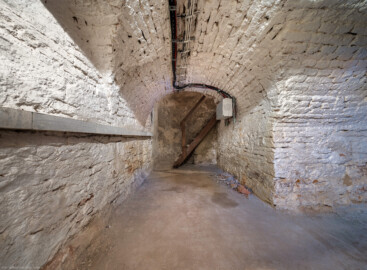 Schloss und Schlossgarten Schwetzingen - Garten - Badhaus - Von innen - Keller - Von Osten - Blick von der Südostecke des gewölbten Kellerraums unterhalb des chinesischen Zimmers (des Teezimmers) nach Westen in den Raum und auf den hölzernen Treppenaufgang zum Zwischenraum zwischen chinesischem Zimmer und nördlicher Vorhalle; Höhe des Kellerraums: ca. 2 Meter (Gesamter Bau: Länge x Breite ca. 18 x 14 Meter, Höhe ca. 10 Meter; Architekt: Nicolas de Pigage (1723-1796); Bauzeit: 1768-1772; Gesamtinstandsetzung innen und außen: 1999-2006) (aufgenommen im Oktober 2025, am frühen Nachmittag) Schloss und Schlossgarten Schwetzingen - Garten - Badhaus - Von innen - Keller - Von Osten - Blick von der Südostecke des gewölbten Kellerraums unterhalb des chinesischen Zimmers (des Teezimmers) nach Westen in den Raum und auf den hölzernen Treppenaufgang zum Zwischenraum zwischen chinesischem Zimmer und nördlicher Vorhalle; Höhe des Kellerraums: ca. 2 Meter (Gesamter Bau: Länge x Breite ca. 18 x 14 Meter, Höhe ca. 10 Meter; Architekt: Nicolas de Pigage (1723-1796); Bauzeit: 1768-1772; Gesamtinstandsetzung innen und außen: 1999-2006) (aufgenommen im Oktober 2025, am frühen Nachmittag)