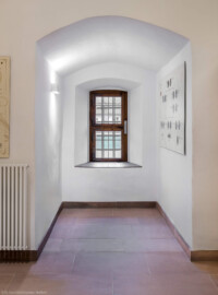 Schloss und Schlossgarten Schwetzingen - Schloss - Mittelbau - Von innen - Erdgeschoss, Nordseite - Besucherzentrum / ehemaliger Hochkeller - Von Westen - Blick vom östlichen Ende des Raums nach Osten in den Standerker (Raum: Länge x Breite: ca. 16 x 6 Meter, Höhe (bis Schlussstein): ca. 3,5 Meter; 4 Joche, 3 Gurtbögen, 3 Kreuzrippengewölbe, ein Kreuzgratgewölbe im Osten; Nordwand: 2 Fenster, 2 vermauerte Öffnungen, Standerker: 1 kleines Fenster, Südwand: 3 Türen, Westwand: verschlossene Durchgangstür) (Mittelbau: Länge Westseite ca. 45 Meter, Breite Süd-/Nordseite ca. 38 Meter; Wiederaufbau / Erweiterung: 1698-1717; Architekt: Johann Adam Breunig) (aufgenommen im November 2025, am späten Vormittag)