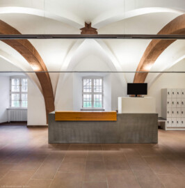 Schloss und Schlossgarten Schwetzingen - Schloss - Mittelbau - Von innen - Erdgeschoss, Nordseite - Besucherzentrum / ehemaliger Hochkeller - Von Süden - Blick vom westlichen Eingang in der Vorhalle nach Norden in den gewölbten Raum; im 16. Jahrhundert diente der Raum als Hofstube (eine Art Mensa), später als Hochkeller, ab 2016 als Besucherzentrum; der Boden des Raum lag früher 4 Treppenstufen tiefer, der Raum besaß Zwischenwände, ein Gewölbeschlusstein trägt die Jahreszahl 1527 (Raum: Länge x Breite: ca. 16 x 6 Meter, Höhe (bis Schlussstein): ca. 3,5 Meter; 4 Joche, 3 Gurtbögen, 3 Kreuzrippengewölbe, ein Kreuzgratgewölbe im Osten; Nordwand: 2 Fenster, 2 vermauerte Öffnungen, Standerker: 1 kleines Fenster, Südwand: 3 Türen, Westwand: verschlossene Durchgangstür) (Mittelbau: Länge Westseite ca. 45 Meter, Breite Süd-/Nordseite ca. 38 Meter; Wiederaufbau / Erweiterung: 1698-1717; Architekt: Johann Adam Breunig) (aufgenommen im November 2025, um die Mittagszeit)