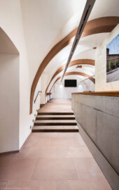 Schloss und Schlossgarten Schwetzingen - Schloss - Mittelbau - Von innen - Erdgeschoss, Nordseite - Besucherzentrum / ehemaliger Hochkeller - Von Osten - Blick vom Durchgang zum nordöstlichen Treppenhaus nach Westen in den gewölbten Raum; mittig zwei Durchgänge (nicht sichtbar) zur Vorhalle des Raums; im 16. Jahrhundert diente der Raum als Hofstube (eine Art Mensa), später als Hochkeller, ab 2016 als Besucherzentrum; der Boden des Raum lag früher 4 Treppenstufen tiefer, der Raum besaß Zwischenwände, ein Gewölbeschlusstein trägt die Jahreszahl 1527 (Raum: Länge x Breite: ca. 16 x 6 Meter, Höhe (bis Schlussstein): ca. 3,5 Meter; 4 Joche, 3 Gurtbögen, 3 Kreuzrippengewölbe, ein Kreuzgratgewölbe im Osten; Nordwand: 2 Fenster, 2 vermauerte Öffnungen, Standerker: 1 kleines Fenster, Südwand: 3 Türen, Westwand: verschlossene Durchgangstür) (Mittelbau: Länge Westseite ca. 45 Meter, Breite Süd-/Nordseite ca. 38 Meter; Wiederaufbau / Erweiterung: 1698-1717; Architekt: Johann Adam Breunig) (aufgenommen im November 2025, am späten Vormittag) Schloss und Schlossgarten Schwetzingen - Schloss - Mittelbau - Von innen - Erdgeschoss, Nordseite - Besucherzentrum / ehemaliger Hochkeller - Von Osten - Blick vom Durchgang zum nordöstlichen Treppenhaus nach Westen in den gewölbten Raum; mittig zwei Durchgänge (nicht sichtbar) zur Vorhalle des Raums; im 16. Jahrhundert diente der Raum als Hofstube (eine Art Mensa), später als Hochkeller, ab 2016 als Besucherzentrum; der Boden des Raum lag früher 4 Treppenstufen tiefer, der Raum besaß Zwischenwände, ein Gewölbeschlusstein trägt die Jahreszahl 1527 (Raum: Länge x Breite: ca. 16 x 6 Meter, Höhe (bis Schlussstein): ca. 3,5 Meter; 4 Joche, 3 Gurtbögen, 3 Kreuzrippengewölbe, ein Kreuzgratgewölbe im Osten; Nordwand: 2 Fenster, 2 vermauerte Öffnungen, Standerker: 1 kleines Fenster, Südwand: 3 Türen, Westwand: verschlossene Durchgangstür) (Mittelbau: Länge Westseite ca. 45 Meter, Breite Süd-/Nordseite ca. 38 Meter; Wiederaufbau / Erweiterung: 1698-1717; Architekt: Johann Adam Breunig) (aufgenommen im November 2025, am späten Vormittag)