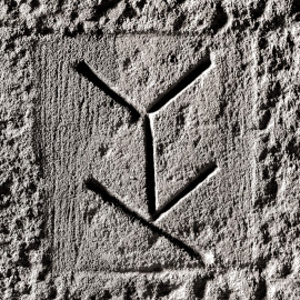 Schloss und Schlossgarten Schwetzingen - Schloss - Mittelbau - Von innen - Erdgeschoss, Nordseite - Besucherzentrum / ehemaliger Hochkeller - 2. Gurtbogen von Osten - Blick auf das 11. Steinmetzzeichen (von Süden und von unten aus gezählt) (Raum: Länge x Breite: ca. 16 x 6 Meter, Höhe (bis Schlussstein): ca. 3,5 Meter; 4 Joche, 3 Gurtbögen, 3 Kreuzrippengewölbe, ein Kreuzgratgewölbe im Osten; Nordwand: 2 Fenster, 2 vermauerte Öffnungen, Standerker: 1 kleines Fenster, Südwand: 3 Türen, Ostwand: verschlossene Durchgangstür) (Mittelbau: Länge Westseite ca. 45 Meter, Breite Süd-/Nordseite ca. 38 Meter; Wiederaufbau / Erweiterung: 1698-1717; Architekt: Johann Adam Breunig) (aufgenommen im November 2025, am frühen Nachmittag) Schloss und Schlossgarten Schwetzingen - Schloss - Mittelbau - Von innen - Erdgeschoss, Nordseite - Besucherzentrum / ehemaliger Hochkeller - 2. Gurtbogen von Osten - Blick auf das 11. Steinmetzzeichen (von Süden und von unten aus gezählt) (Raum: Länge x Breite: ca. 16 x 6 Meter, Höhe (bis Schlussstein): ca. 3,5 Meter; 4 Joche, 3 Gurtbögen, 3 Kreuzrippengewölbe, ein Kreuzgratgewölbe im Osten; Nordwand: 2 Fenster, 2 vermauerte Öffnungen, Standerker: 1 kleines Fenster, Südwand: 3 Türen, Ostwand: verschlossene Durchgangstür) (Mittelbau: Länge Westseite ca. 45 Meter, Breite Süd-/Nordseite ca. 38 Meter; Wiederaufbau / Erweiterung: 1698-1717; Architekt: Johann Adam Breunig) (aufgenommen im November 2025, am frühen Nachmittag)