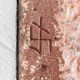 Schloss und Schlossgarten Schwetzingen - Schloss - Nordflügel, Nord-Süd-Teil - Schlosskapelle - Südostecke - Von Norden - Blick auf das Steinmetzzeichen an der linken Seite des zweitobersten Quaders der Südwand (Schlosskapelle: Länge ca. 14 Meter, Breite ca. 10 Meter, Höhe: bis unter das Dach, Achsen: 6, Eingang: Ostseite; Bauzeit: zwischen 1698 und 1715; Architekten: Johann Adam Breunig, Simon Sarto; Umbau innen im klassizistischen Stil: 1804-1806, Architekt: Friedrich Weinbrenner) (aufgenommen im November 2025, am Nachmittag) Schloss und Schlossgarten Schwetzingen - Schloss - Nordflügel, Nord-Süd-Teil - Schlosskapelle - Südostecke - Von Norden - Blick auf das Steinmetzzeichen an der linken Seite des zweitobersten Quaders der Südwand (Schlosskapelle: Länge ca. 14 Meter, Breite ca. 10 Meter, Höhe: bis unter das Dach, Achsen: 6, Eingang: Ostseite; Bauzeit: zwischen 1698 und 1715; Architekten: Johann Adam Breunig, Simon Sarto; Umbau innen im klassizistischen Stil: 1804-1806, Architekt: Friedrich Weinbrenner) (aufgenommen im November 2025, am Nachmittag)