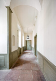 Schloss und Schlossgarten Schwetzingen - Schloss - Mittelbau - Von innen - Nördöstliches Treppenhaus, 1. Obergeschoss - Von Osten - Blick vom Ende der Treppe ins 1. Obergeschoss nach Westen in den Gang und auf Türen; die Tür in der Bildmitte führt in das Credenzzimmer, die Tür rechts in das erste Vorzimmer (Mittelbau: Länge Westseite ca. 45 Meter, Breite Süd-/Nordseite ca. 38 Meter; Wiederaufbau / Erweiterung: 1698-1717; Architekt: Johann Adam Breunig) (aufgenommen im November 2025, am frühen Nachmittag) Schloss und Schlossgarten Schwetzingen - Schloss - Mittelbau - Von innen - Nördöstliches Treppenhaus, 1. Obergeschoss - Von Osten - Blick vom Ende der Treppe ins 1. Obergeschoss nach Westen in den Gang und auf Türen; die Tür in der Bildmitte führt in das Credenzzimmer, die Tür rechts in das erste Vorzimmer (Mittelbau: Länge Westseite ca. 45 Meter, Breite Süd-/Nordseite ca. 38 Meter; Wiederaufbau / Erweiterung: 1698-1717; Architekt: Johann Adam Breunig) (aufgenommen im November 2025, am frühen Nachmittag)