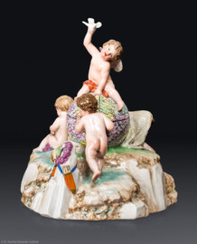 Schloss und Schlossgarten Schwetzingen - Schloss - Mittelbau - Von innen - 1. Obergeschoss - Appartment des Kurfürsten - Zweites Vorzimmer - Ostwand, Halbschrank - Porzellanplastik: "Amor als Weltbezwinger“, über Felsensockel auf mittiger Weltkugel sitzende Amorette, einen Vogel in die Luft haltend, flankiert von drei Putten (Frankenthaler Porzellan, Entwurf: Peter Melchior (1747-1825), Datierung: um 1783, Höhe ca. 17 cm) (aufgenommen im Dezember 2025, am späten Vormittag)