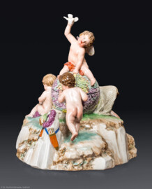 Schloss und Schlossgarten Schwetzingen - Schloss - Mittelbau - Von innen - 1. Obergeschoss - Appartment des Kurfürsten - Zweites Vorzimmer - Ostwand, Halbschrank - Porzellanplastik: "Amor als Weltbezwinger“, über Felsensockel auf mittiger Weltkugel sitzende Amorette, einen Vogel in die Luft haltend, flankiert von drei Putten (Frankenthaler Porzellan, Entwurf: Peter Melchior (1747-1825), Datierung: um 1783, Höhe ca. 17 cm) (aufgenommen im Dezember 2025, am späten Vormittag)