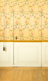 Schloss und Schlossgarten Schwetzingen - Schloss - Mittelbau - Von innen - 1. Obergeschoss - Appartment des Kurfürsten - Kabinett - Ostwand - Von Westen - Blick auf die Tapetentür des Kabinetts; hinter der Tür befindet sich der kleine Raum mit dem obersten Treppenabsatz des nordwestlichen Treppenhauses und dem Zugang zur Retirade (zum "stillen Örtchen"); links der Griff (als Quaste verziert) und das Seil nach oben für den Klingelzug zum Rufen des Kammerdieners; die Wandbespannung besteht aus Seidendamast mit einem Blumendekor (aufgenommen im Februar 2026, am frühen Nachmittag) Schloss und Schlossgarten Schwetzingen - Schloss - Mittelbau - Von innen - 1. Obergeschoss - Appartment des Kurfürsten - Kabinett - Ostwand - Von Westen - Blick auf die Tapetentür des Kabinetts; hinter der Tür befindet sich der kleine Raum mit dem obersten Treppenabsatz des nordwestlichen Treppenhauses und dem Zugang zur Retirade (zum "stillen Örtchen"); links der Griff (als Quaste verziert) und das Seil nach oben für den Klingelzug zum Rufen des Kammerdieners; die Wandbespannung besteht aus Seidendamast mit einem Blumendekor (aufgenommen im Februar 2026, am frühen Nachmittag)