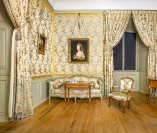 Schloss und Schlossgarten Schwetzingen - Schloss - Mittelbau - Von innen - 1. Obergeschoss - Appartment des Kurfürsten - Kabinett - Von Osten - Blick von der Tür zum Kabinett nach Westen auf eine Sitzgruppe, bestehend aus einem Canapé (Sofa), einem Fauteuil (Polstersessel mit Armlehnen) und einem kleinen Tisch; ganz rechts ein Verwandlungstisch; oberhalb der Bildmitte ein Porträt der Maria Josepha Seyffert (1748-1771, seit 1769 Gräfin von Heydeck), eine Mätresse des Kurfürsten Carl Theodor; links ein Porträt von Kurfürst Carl Theodor (1724-1799, reg. 1742-1799) (aufgenommen im Februar 2026, am späten Vormittag) Schloss und Schlossgarten Schwetzingen - Schloss - Mittelbau - Von innen - 1. Obergeschoss - Appartment des Kurfürsten - Kabinett - Von Osten - Blick von der Tür zum Kabinett nach Westen auf eine Sitzgruppe, bestehend aus einem Canapé (Sofa), einem Fauteuil (Polstersessel mit Armlehnen) und einem kleinen Tisch; ganz rechts ein Verwandlungstisch; oberhalb der Bildmitte ein Porträt der Maria Josepha Seyffert (1748-1771, seit 1769 Gräfin von Heydeck), eine Mätresse des Kurfürsten Carl Theodor; links ein Porträt von Kurfürst Carl Theodor (1724-1799, reg. 1742-1799) (aufgenommen im Februar 2026, am späten Vormittag)