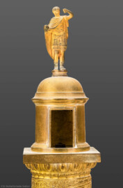 Schloss und Schlossgarten Schwetzingen - Schloss - Mittelbau - Von innen - 1. Obergeschoss - Appartment des Kurfürsten - Arbeitskabinett - Schreibtisch - Ausschnitt aus der Nachbildung der Trajanssäule auf dem Trajansforum in Rom; dargestellt ist die Plattform über der eigentlichen Säule mit der Statue des Kaisers Trajan (53–117) (Original: Ehrensäule für den römischen Kaiser Trajan (53–117), Architekt Apollodorus von Damaskus (um 65 bis um 130), Bauzeit 112/113, Gesamthöhe 38,4 Meter, Darstellung von 2500 menschlichen Figuren; originale Nachbildung: Goldschmied Luigi Valadier (1726-1785), Höhe ca. 2 Meter, Datierung 1774-80, Erwerb 1783 durch Kurfürst Carl-Theodor, Aufbewahrung Schatzkammer der Residenz München; hier abgebildete Nachbildung: Höhe ca. 85 cm) (aufgenommen im Februar 2026, am Nachmittag) Schloss und Schlossgarten Schwetzingen - Schloss - Mittelbau - Von innen - 1. Obergeschoss - Appartment des Kurfürsten - Arbeitskabinett - Schreibtisch - Ausschnitt aus der Nachbildung der Trajanssäule auf dem Trajansforum in Rom; dargestellt ist die Plattform über der eigentlichen Säule mit der Statue des Kaisers Trajan (53–117) (Original: Ehrensäule für den römischen Kaiser Trajan (53–117), Architekt Apollodorus von Damaskus (um 65 bis um 130), Bauzeit 112/113, Gesamthöhe 38,4 Meter, Darstellung von 2500 menschlichen Figuren; originale Nachbildung: Goldschmied Luigi Valadier (1726-1785), Höhe ca. 2 Meter, Datierung 1774-80, Erwerb 1783 durch Kurfürst Carl-Theodor, Aufbewahrung Schatzkammer der Residenz München; hier abgebildete Nachbildung: Höhe ca. 85 cm) (aufgenommen im Februar 2026, am Nachmittag)