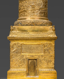 Schloss und Schlossgarten Schwetzingen - Schloss - Mittelbau - Von innen - 1. Obergeschoss - Appartment des Kurfürsten - Arbeitskabinett - Schreibtisch - Ausschnitt aus der Nachbildung der Trajanssäule auf dem Trajansforum in Rom; dargestellt ist der Sockel der Säule mit dem Eingang zur Wendeltreppe und der Tafel mit der Inschrift; die Inschrift lautet im Original “SENATVS·POPVLVSQVE·ROMANVS / IMP·CAESARI·DIVI·NERVAE·F·NERVAE / TRAIANO·AVG·GERM·DACICO·PONTIF / MAXIMO·TRIB·POT·XVII·IMP·VI·COS·VI·P·P / AD·DECLARANDVM·QVANTAE·ALTITVDINIS / MONS·ET·LOCVS·TANT<IS·OPER>IBVS·SIT·EGESTVS” / "Senat und Volk von Rom [weihen dieses Monument] dem Imperator Caesar Nerva Traianus Augustus, Sohn des vergöttlichten Nerva, Bezwinger der Germanen und der Daker, Pontifex maximus, Inhaber der tribunizischen Amtsgewalt zum 17. Mal, siegreicher Feldherr zum sechsten Mal, Consul zum sechsten Mal, P[ater] P[atriae], um zu zeigen, wie hoch der Hügel und das Gelände war, das für diese umfangreichen Baumaßnahmen entfernt wurde" (Original: Ehrensäule für den römischen Kaiser Trajan (53–117), Architekt Apollodorus von Damaskus (um 65 bis um 130), Bauzeit 112/113, Gesamthöhe 38,4 Meter, Darstellung von 2500 menschlichen Figuren; originale Nachbildung: Goldschmied Luigi Valadier (1726-1785), Höhe ca. 2 Meter, Datierung 1774-80, Erwerb 1783 durch Kurfürst Carl-Theodor, Aufbewahrung Schatzkammer der Residenz München; hier abgebildete Nachbildung: Höhe ca. 85 cm) (aufgenommen im Februar 2026, am Nachmittag)