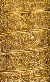 Schloss und Schlossgarten Schwetzingen - Schloss - Mittelbau - Von innen - 1. Obergeschoss - Appartment des Kurfürsten - Arbeitskabinett - Schreibtisch - Ausschnitt aus der Nachbildung der Trajanssäule auf dem Trajansforum in Rom; dargestellt sind Windungen der eigentlichen Säule mit Szenen aus den Kriegen gegen die Daker in den Jahren 101/102 und 105/106 (Original: Ehrensäule für den römischen Kaiser Trajan (53–117), Architekt Apollodorus von Damaskus (um 65 bis um 130), Bauzeit 112/113, Gesamthöhe 38,4 Meter, Darstellung von 2500 menschlichen Figuren; originale Nachbildung: Goldschmied Luigi Valadier (1726-1785), Höhe ca. 2 Meter, Datierung 1774-80, Erwerb 1783 durch Kurfürst Carl-Theodor, Aufbewahrung Schatzkammer der Residenz München; hier abgebildete Nachbildung: Höhe ca. 85 cm) (aufgenommen im Februar 2026, am Nachmittag) Schloss und Schlossgarten Schwetzingen - Schloss - Mittelbau - Von innen - 1. Obergeschoss - Appartment des Kurfürsten - Arbeitskabinett - Schreibtisch - Ausschnitt aus der Nachbildung der Trajanssäule auf dem Trajansforum in Rom; dargestellt sind Windungen der eigentlichen Säule mit Szenen aus den Kriegen gegen die Daker in den Jahren 101/102 und 105/106 (Original: Ehrensäule für den römischen Kaiser Trajan (53–117), Architekt Apollodorus von Damaskus (um 65 bis um 130), Bauzeit 112/113, Gesamthöhe 38,4 Meter, Darstellung von 2500 menschlichen Figuren; originale Nachbildung: Goldschmied Luigi Valadier (1726-1785), Höhe ca. 2 Meter, Datierung 1774-80, Erwerb 1783 durch Kurfürst Carl-Theodor, Aufbewahrung Schatzkammer der Residenz München; hier abgebildete Nachbildung: Höhe ca. 85 cm) (aufgenommen im Februar 2026, am Nachmittag)