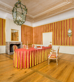 Schloss und Schlossgarten Schwetzingen - Schloss - Mittelbau - Von innen - 1. Obergeschoss - Appartment des Kurfürsten - Konferenzzimmer - Von Südwest - Blick auf den Konferenztisch (mit Schreibzeuggarnituren, Kerzen und Papieren) (aufgenommen im Februar 2026, am Nachmittag)
