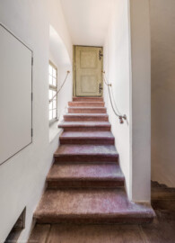 Schloss und Schlossgarten Schwetzingen - Schloss - Mittelbau - Von innen - Südwestliches Treppenhaus - Von Norden - Blick vom Treppenabsatz im 3. Obergeschoss nach Süden auf die Treppe und auf eine Tür zum Dachgeschoss (Mittelbau: Länge Westseite ca. 45 Meter, Breite Süd-/Nordseite ca. 38 Meter; Wiederaufbau / Erweiterung: 1698-1717; Architekt: Johann Adam Breunig) (aufgenommen im März 2026, am Nachmittag)