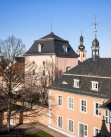 Schloss und Schlossgarten Schwetzingen - Sonstige Bauten - Oberes Wasserwerk - Wasserturm - Von außen - Von Südwest - Blick vom Nordfenster im 3. Obergeschoss des nördlichen Eckpavillons des Schlossmittelbaus auf den Wasserturm des Oberen Wasserwerks (in der Bildmitte); links davon die Westseite und das Dach des Kühlhauses; rechts des Wasserturms die Westseite des Querbaus des Nordflügels (des Hofkavaliersflügels, mit der Schlosskapelle), oben ein Dachreiter mit einem Hemmerschen Fünfspitz und einer Wetterfahne; zwischen Wasserturm und Dachtreiter im Hintergrund der Turm von St. Pankratius (Gesamte Anlage Brunnenstube, Pumpenstube, Räderwerk, Wasserturm und Kühlhaus): Länge x Breite: ca. 30 x 29 Meter, Wasserturm: Länge x Breite: ca. 14 x 14 Meter, Firsthöhe ca. 24 Meter; Bauzeit Anlage: um 1774, Gesamtinstandsetzung: 1994–2000; Architekt: Nicolas de Pigage, Brunnenmeister: Thomas Breuer) (aufgenommen im März 2026, am späten Nachmittag)