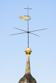 Schloss und Schlossgarten Schwetzingen - Schloss - Nordflügel / Hofkavaliersflügel - Von Südwest - Blick vom Nordfenster im 3. Obergeschoss des nördlichen Eckpavillons des Schlossmittelbaus auf den Dachreiter in der Nordwestecke des Nordflügels; oben ein Hemmerscher Fünfspitz mit einer Wetterfahne (Wappen der Kurpfalz), darunter ein Turmknopf, darunter der Ansatz einer Welschen Haube (NordFlügel: L-förmig, Länge x Breite Längsbau ca. 50 x 14 Meter, Querbau ca. 15 x 12 Meter; Architekt: Johann Adam Breunig (1660-1727); Fertigstellung: 1710) (aufgenommen im März 2026, am späten Nachmittag) Schloss und Schlossgarten Schwetzingen - Schloss - Nordflügel / Hofkavaliersflügel - Von Südwest - Blick vom Nordfenster im 3. Obergeschoss des nördlichen Eckpavillons des Schlossmittelbaus auf den Dachreiter in der Nordwestecke des Nordflügels; oben ein Hemmerscher Fünfspitz mit einer Wetterfahne (Wappen der Kurpfalz), darunter ein Turmknopf, darunter der Ansatz einer Welschen Haube (NordFlügel: L-förmig, Länge x Breite Längsbau ca. 50 x 14 Meter, Querbau ca. 15 x 12 Meter; Architekt: Johann Adam Breunig (1660-1727); Fertigstellung: 1710) (aufgenommen im März 2026, am späten Nachmittag)