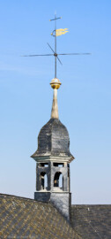 Schloss und Schlossgarten Schwetzingen - Schloss - Nordflügel / Hofkavaliersflügel - Von Süden - Blick vom Nordfenster im 3. Obergeschoss des nördlichen Turms des Schlossmittelbaus auf den Dachreiter in der Nordwestecke des Nordflügels; oben ein Hemmerscher Fünfspitz mit einer Wetterfahne (Wappen der Kurpfalz), darunter ein Turmknopf, darunter eine Welsche Haube, darunter die Laterne  (NordFlügel: L-förmig, Länge x Breite Längsbau ca. 50 x 14 Meter, Querbau ca. 15 x 12 Meter; Architekt: Johann Adam Breunig (1660-1727); Fertigstellung: 1710) (aufgenommen im März 2026, am späten Vormittag)