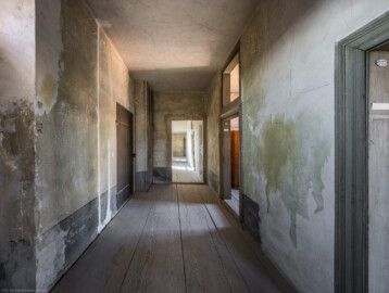 Schloss und Schlossgarten Schwetzingen - Schloss - Mittelbau - Von innen - 3. Obergeschoss - Südlicher Gang - Von Osten - Blick von der Tür zum Schacht des südlichen Turms nach Westen in den südlichen Gang; die Tür links hinten führt in den alten Treppenturm; der hölzerne Vorbau dahinter gehört zu einem Abort; die Tür in der Bildmitte führt in den Raum 230 (danach in den Raum 231, die Küche); die Tür rechts hinten im Gang führt in den Raum 228, die Tür rechts vorne in den Raum 227 (aufgenommen im März 2026, am frühen Nachmittag) Schloss und Schlossgarten Schwetzingen - Schloss - Mittelbau - Von innen - 3. Obergeschoss - Südlicher Gang - Von Osten - Blick von der Tür zum Schacht des südlichen Turms nach Westen in den südlichen Gang; die Tür links hinten führt in den alten Treppenturm; der hölzerne Vorbau dahinter gehört zu einem Abort; die Tür in der Bildmitte führt in den Raum 230 (danach in den Raum 231, die Küche); die Tür rechts hinten im Gang führt in den Raum 228, die Tür rechts vorne in den Raum 227 (aufgenommen im März 2026, am frühen Nachmittag)
