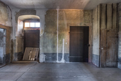 Schloss und Schlossgarten Schwetzingen - Schloss - Mittelbau - Von innen - 3. Obergeschoss - Südlicher Gang - Von Norden - Blick von der Tür zum Raum 228 nach Süden in den südlichen Gang; ganz links der Zugang zum südlichen Turm; links eine eiserne Tür, die ehemals (heute zugemauert) in den Dachstuhl des Querbaus des Südflügels / Hofdamenflügels führte; rechts eine weitere eiserne Tür, die in den Treppenturm führt; ganz rechts ein hölzerner Vorbau, hinter dem sich ein Abort/Abtritt verbirgt (aufgenommen im März 2026, am frühen Nachmittag) Schloss und Schlossgarten Schwetzingen - Schloss - Mittelbau - Von innen - 3. Obergeschoss - Südlicher Gang - Von Norden - Blick von der Tür zum Raum 228 nach Süden in den südlichen Gang; ganz links der Zugang zum südlichen Turm; links eine eiserne Tür, die ehemals (heute zugemauert) in den Dachstuhl des Querbaus des Südflügels / Hofdamenflügels führte; rechts eine weitere eiserne Tür, die in den Treppenturm führt; ganz rechts ein hölzerner Vorbau, hinter dem sich ein Abort/Abtritt verbirgt (aufgenommen im März 2026, am frühen Nachmittag)