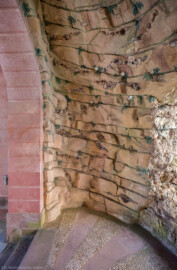 Schloss und Schlossgarten Schwetzingen - Garten - Badhausanlage - Perspektiv - Grotte - Von Osten - Blick von der Ostseite der Grotte nach Westen in die Felsengrotte, geschmückt mit Muscheln, Algen, Halbedelsteinen und Mineralkristallen; links der Rundbogen der Halle, rechts die Öffnung zur Vorgrotte, die den Blick auf das Gemälde ("Ende der Welt") freigibt (Perspektiv: Abmessungen Länge x Breite x Höhe: Laubengang ca. 40 x 3,5 x 4,5 Meter, Bau ca. 16 x 4,5 bis 11 x 6,5 Meter, Bildwand ca. 9 x 1 x 7,5 Meter; Fertigstellung: 1775, Gesamtinstandsetzung: 1988-1991, Restaurierung Laubengang: 2022; Architekt: Nicolas de Pigage) (aufgenommen im April 2026, am Nachmittag)