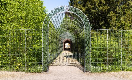 Schloss und Schlossgarten Schwetzingen - Garten - Badhausanlage - Perspektiv - Von Süden - Blick auf und in den Laubengang (Berceau de treillage) zum Perspektiv / zum "Ende der Welt" (Perspektiv: Abmessungen Länge x Breite x Höhe: Laubengang ca. 40 x 3,5 x 4,5 Meter, Bau ca. 16 x 4,5 bis 11 x 6,5 Meter, Bildwand ca. 9 x 1 x 7,5 Meter; Fertigstellung: 1775, Gesamtinstandsetzung: 1988-1991, Restaurierung Laubengang: 2022; Architekt: Nicolas de Pigage) (aufgenommen im April 2026, am frühen Nachmittag)