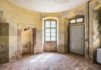 Schloss und Schlossgarten Schwetzingen - Garten - Badhausanlage - Badhausküche - Von innen - Rotunde - Von Norden - Blick von der Tür zum Heizraum nach Süden in den runden Eingangsraum, auf die Nische für den Wandschrank (links) sowie auf die Eingangstür (rechts) (Gesamter Bau: Länge x Breite (winkelförmig) ca. 13 x 11 Meter, Höhe (über Rotunde) ca. 8 Meter; Raum: Durchmesser ca. 5 Meter, Höhe ca. 3 Meter; Architekt: Nicolas de Pigage (1723-1796); Bauzeit: 1768-1772, Dachinstandsetzung: 1983-1985, Instandsetzung: 2013-2015) (aufgenommen im April 2026, am frühen Nachmittag) Schloss und Schlossgarten Schwetzingen - Garten - Badhausanlage - Badhausküche - Von innen - Rotunde - Von Norden - Blick von der Tür zum Heizraum nach Süden in den runden Eingangsraum, auf die Nische für den Wandschrank (links) sowie auf die Eingangstür (rechts) (Gesamter Bau: Länge x Breite (winkelförmig) ca. 13 x 11 Meter, Höhe (über Rotunde) ca. 8 Meter; Raum: Durchmesser ca. 5 Meter, Höhe ca. 3 Meter; Architekt: Nicolas de Pigage (1723-1796); Bauzeit: 1768-1772, Dachinstandsetzung: 1983-1985, Instandsetzung: 2013-2015) (aufgenommen im April 2026, am frühen Nachmittag)