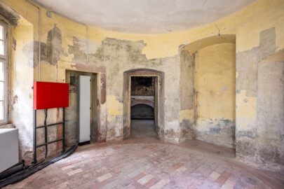 Schloss und Schlossgarten Schwetzingen - Garten - Badhausanlage - Badhausküche - Von innen - Rotunde - Von Süden - Blick vom südlichen Fenster nach Norden in den runden Eingangsraum; mittig die Tür zum Heizraum (mit der Empore für einen Kessel), links ein (ehemaliger) Wandschrank, rechts eine Wandnische (ursprünglich als zweite Außentür geplant), ganz rechts das Gewände der Tür zur Küche (Gesamter Bau: Länge x Breite (winkelförmig) ca. 13 x 11 Meter, Höhe (über Rotunde) ca. 8 Meter; Raum: Durchmesser ca. 5 Meter, Höhe ca. 3 Meter; Architekt: Nicolas de Pigage (1723-1796); Bauzeit: 1768-1772, Dachinstandsetzung: 1983-1985, Instandsetzung: 2013-2015) (aufgenommen im April 2026, am Nachmittag) Schloss und Schlossgarten Schwetzingen - Garten - Badhausanlage - Badhausküche - Von innen - Rotunde - Von Süden - Blick vom südlichen Fenster nach Norden in den runden Eingangsraum; mittig die Tür zum Heizraum (mit der Empore für einen Kessel), links ein (ehemaliger) Wandschrank, rechts eine Wandnische (ursprünglich als zweite Außentür geplant), ganz rechts das Gewände der Tür zur Küche (Gesamter Bau: Länge x Breite (winkelförmig) ca. 13 x 11 Meter, Höhe (über Rotunde) ca. 8 Meter; Raum: Durchmesser ca. 5 Meter, Höhe ca. 3 Meter; Architekt: Nicolas de Pigage (1723-1796); Bauzeit: 1768-1772, Dachinstandsetzung: 1983-1985, Instandsetzung: 2013-2015) (aufgenommen im April 2026, am Nachmittag)
