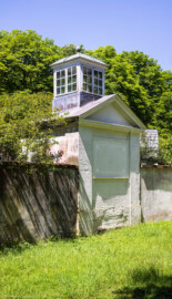 Schloss und Schlossgarten Schwetzingen - Garten - Badhausanlage - Östliches Achathäuschen - Von Südost - Blick vom Garten der Badhausküche auf die Rückseite des östlichen Achathäuschens; ganz oben die teils verglaste Dachlaterne zur Beleuchtung des Inneren, darunter ein Dreiecksgiebel, darunter zwei leere Felder (Achathäuschen: Abmessungen Breite x Tiefe x Höhe 3,2 x 3,0 x 6,4 Meter, Innenraum Breite x Tiefe ca. 2 x 2 Meter; Architekt: Nicolas de Pigage, Fertigstellung: um 1775, Instandsetzung: 1991 - 1995) (aufgenommen im Mai 2026, am frühen Nachmittag)